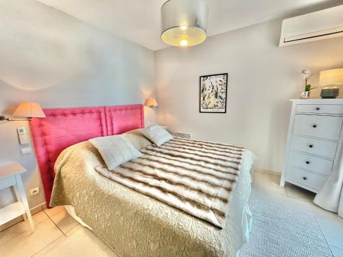 een slaapkamer met een bed met een roze hoofdeinde bij Bristol by Welcome to Cannes in Cannes