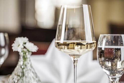 two glasses of white wine sitting on a table at Hotel Norica - Thermenhotels Gastein mit dem Bademantel direkt in die Therme in Bad Hofgastein