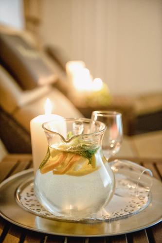 a glass vase on a plate with a candle at Hotel Norica - Thermenhotels Gastein mit dem Bademantel direkt in die Therme in Bad Hofgastein