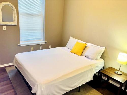 una camera da letto con un grande letto bianco con cuscini gialli di Two Bedroom Queen Bed Suite a Harrisburg