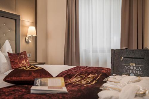 a hotel room with a bed with a book on it at Hotel Norica - Thermenhotels Gastein mit dem Bademantel direkt in die Therme in Bad Hofgastein
