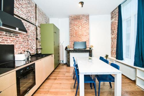 a kitchen with a white table and blue chairs at Cozy and confortable room near Brussels Central Station in Brussels
