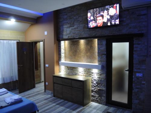 a room with a tv on a brick wall at Rooms&Restaurant 43 in Belgrade