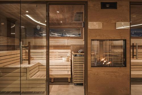 Zimmer mit Bänken und Kamin in einem Raum in der Unterkunft Hotel Norica - Thermenhotels Gastein mit dem Bademantel direkt in die Therme in Bad Hofgastein