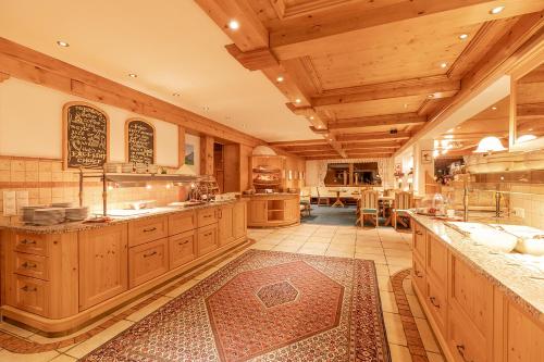 a large kitchen with wooden cabinets and a large island at Hotel Sonnenheim in Sankt Anton am Arlberg