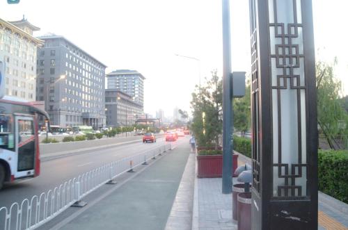 a bus is driving down a city street with cars at Eastwood Inn Xi'an in Xi'an