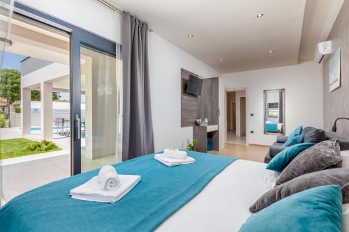 een slaapkamer met een groot bed met blauwe lakens bij Villa Bella Vita by Istrabook in Rebići