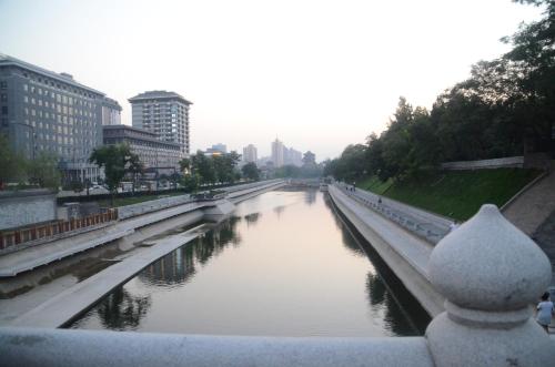 a river in the middle of a city with buildings at Eastwood Inn Xi'an in Xi'an