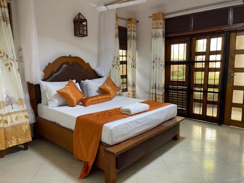 ウクンダにあるSavannah Oasisのベッドルーム1室(オレンジと白の枕が備わるベッド1台付)