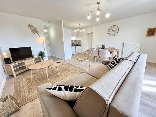 ein Wohnzimmer mit einem Sofa und einem Tisch in der Unterkunft Le Quartz Blanc / Bourg-de-Péage in Bourg-de-Péage