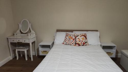 a bedroom with a bed with a mirror and a table at Large 2 Bed Holiday Let in Central Ystradgynlais in Ystradgynlais