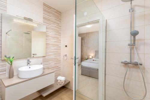 een badkamer met een glazen douche en een wastafel bij Villa Bella Vita by Istrabook in Rebići