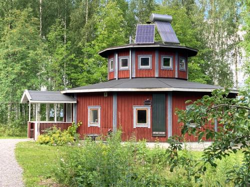 a red house with a solar panel on top of it at STF Växhuset Hostel in Bodarne