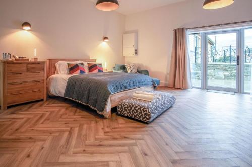 a bedroom with a bed and a wooden floor at Suite 4 - Sleeping Giant Hotel - Pen Y Cae Inn in Brecon