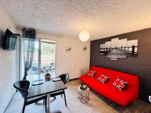 un salon avec un canapé rouge et une table dans l'établissement Studio Cocody 1 Lumio, à Lumio