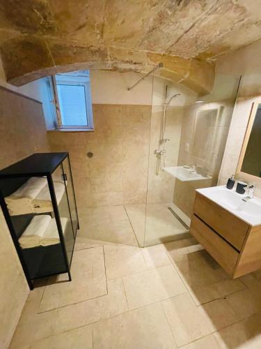 a bathroom with a glass shower and a sink at La Bambina in Senglea