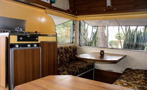 uma sala de estar com um sofá e uma mesa num trailer em Caravana Vintage Star vistas Mar y Montaña em Náquera