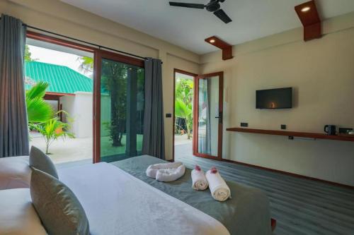 1 dormitorio con 1 cama con 2 toallas en Hanyaa Island Maldives en Hangnaameedhoo