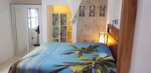 a bedroom with a blue bed with palm trees on it at VillaMobay in Montego Bay