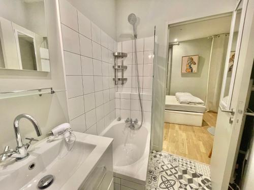 une salle de bain blanche avec une douche et un lavabo dans l'établissement Jaurès by Welcome to Cannes, à Cannes