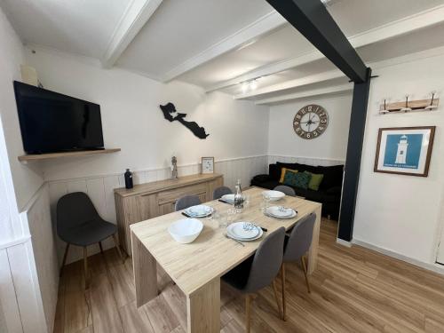 une salle à manger avec une table et des chaises et une télévision dans l'établissement LE PHARE DE LA COTINIERE - Proche port et centre ville, à La Flotte