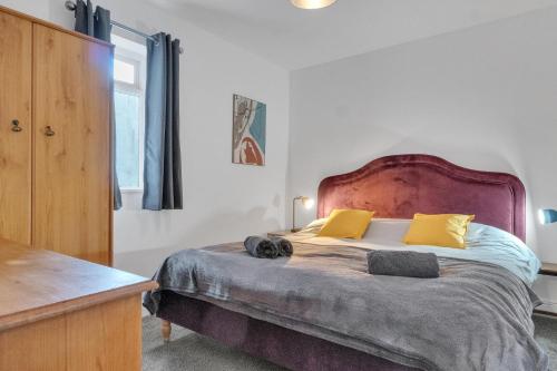 um quarto com uma cama grande e almofadas amarelas em Simply Hove By My Getaways em Brighton & Hove