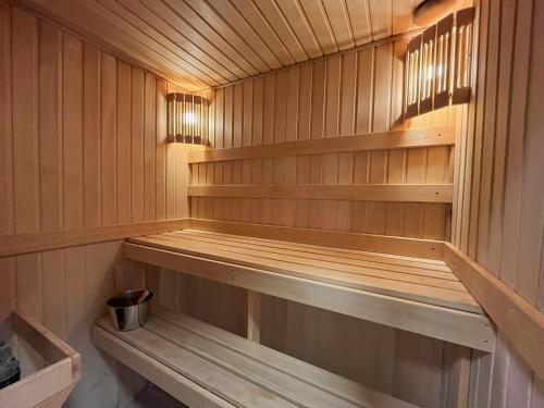 a sauna with wooden shelves and a bucket in it at R-Joki Apartments in Ravijoki