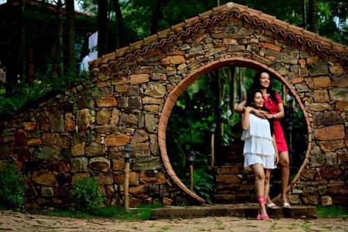 two women are standing in a stone wall at Sereno Barn Eco Stay Chikmagalur in Chikmagalūr