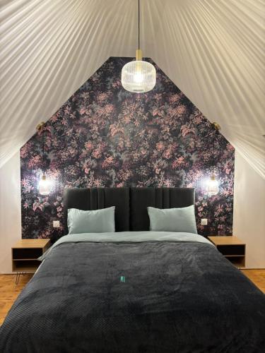 - une chambre avec un grand lit et un mur fleuri dans l'établissement Gîte Les Dorés Musis, à Carency