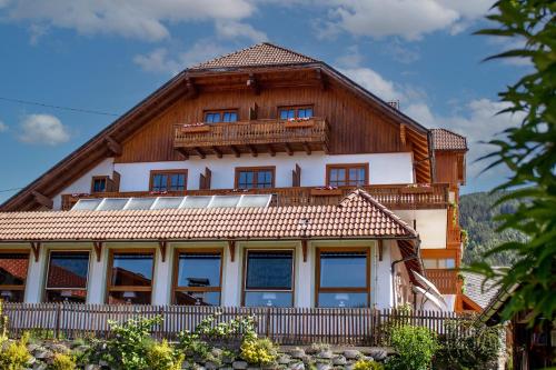 a large house with a wooden roof at Pension Kärnten in Seeboden