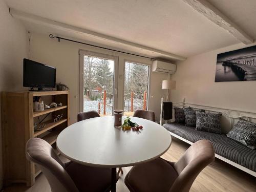 un salon avec une table, des chaises et un canapé dans l'établissement Beach House Buxusson Resort, à České Budějovice