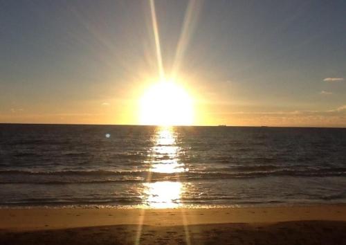 una puesta de sol sobre el océano en una playa en Sunrise Ocean Suites, en Pompano Beach