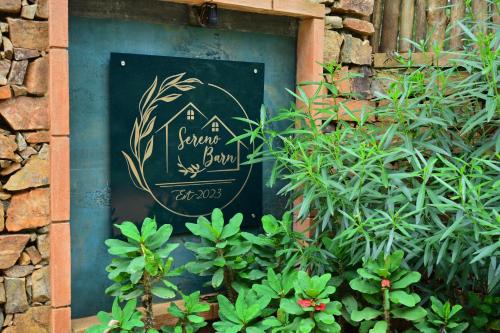 a sign on the side of a building with plants at Sereno Barn Eco Stay Chikmagalur in Chikmagalūr