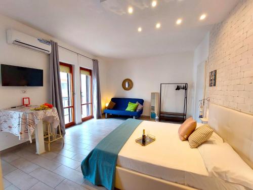 a bedroom with a large bed and a blue couch at Moonlight Sorrento Studios in Sorrento