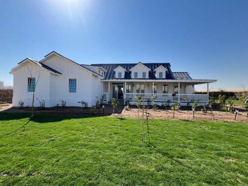 a large white house with a large yard at Prairie in Al Khaznah