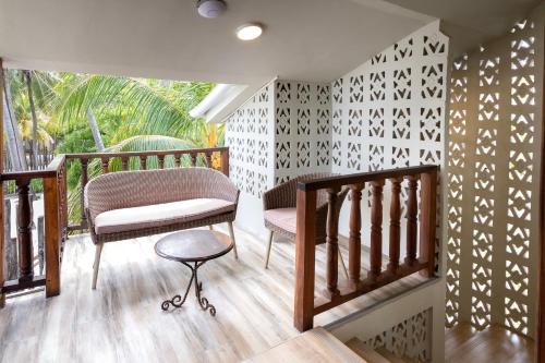 a balcony with a bench and a chair on a wooden floor at RoRi Private Luxury Villas in Bwejuu