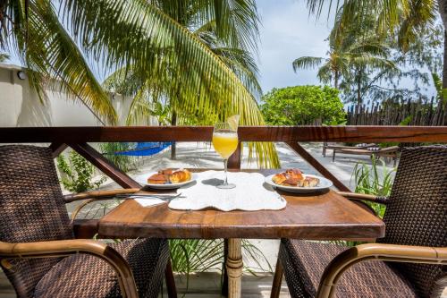 a table with plates of food and a glass of wine at RoRi Private Luxury Villas in Bwejuu