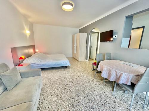 een slaapkamer met een bed, een bank en een tafel bij Themis by Welcome to Cannes in Cannes
