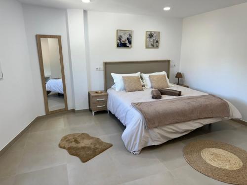 ein Schlafzimmer mit einem großen Bett und einem Spiegel in der Unterkunft Apartamentos Casa Mime in Mogán