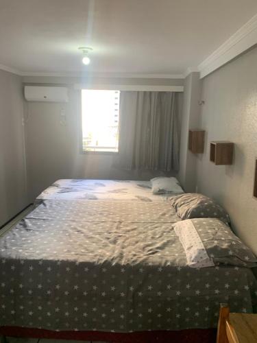 un grande letto in una stanza con finestra di Apartamento Porto de Iracema a Fortaleza