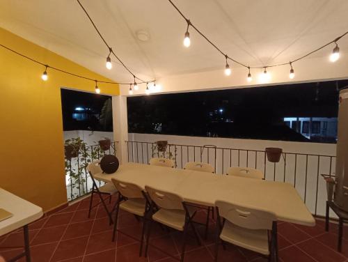 a table and chairs in a room with a balcony at Casa Céntrica en Palenque in Palenque
