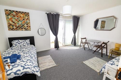 a bedroom with a bed and a table with chairs at Rooms Close to Canary Wharf in London