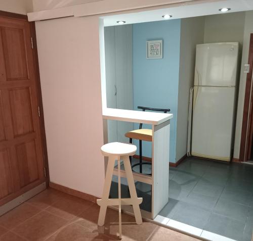 una cucina con bancone e sgabello accanto a un frigorifero di (El departamento) a Pergamino
