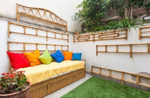 uma cama com almofadas coloridas numa varanda em Case Calliope em Palermo
