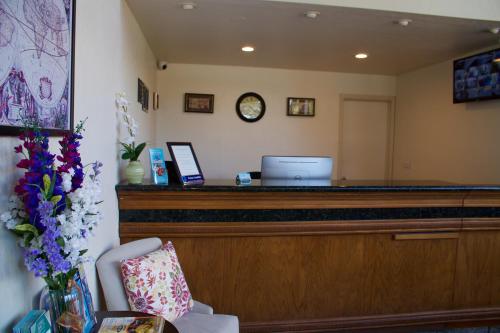a reception desk with a bench and a clock at Munras Inn in Monterey