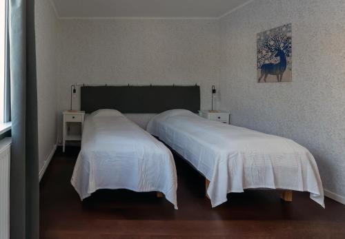 1 dormitorio con 2 camas con sábanas blancas en Lugnt läge i centrala Rättvik, en Rättvik
