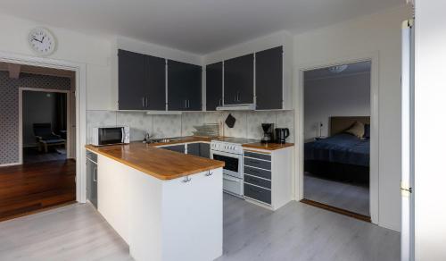 a kitchen with black cabinets and a bed in a room at Lugnt läge i centrala Rättvik in Rättvik