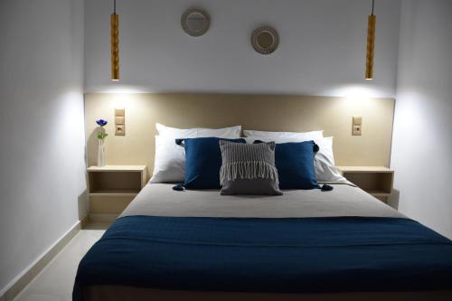 una camera da letto con un grande letto con lenzuola e cuscini blu di Elean a Kavoúsion