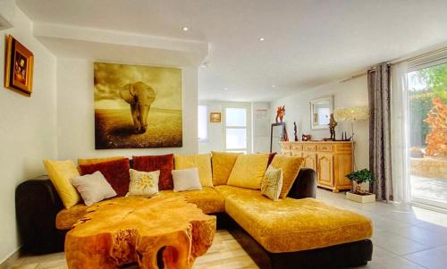 a living room with a couch and an elephant painting at Villa terranga in Calenzana