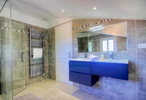 uma casa de banho com um lavatório azul e um chuveiro em Villa terranga em Calenzana